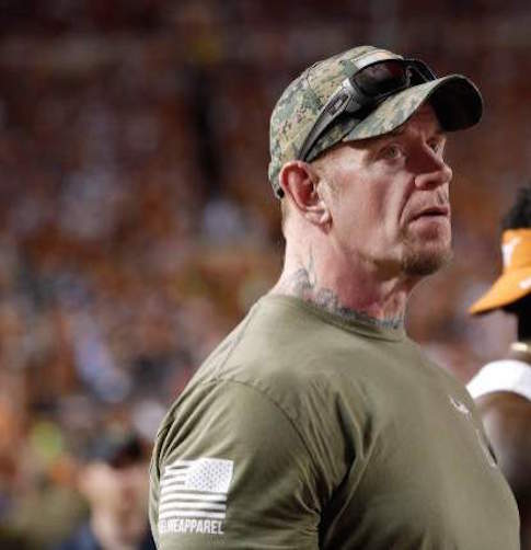 https://www.flexymusic.ng/wp-content/uploads/legend-the-undertaker-watches-from-the-sideline-during-the-game-the-picture.jpeg